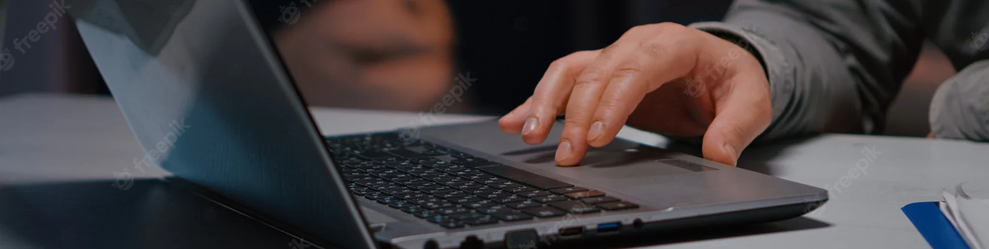 Hand on laptop keyboard, typing.