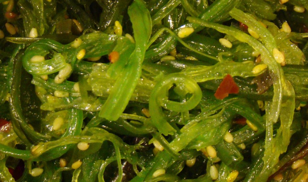 cooked green seaweed with small pale seeds