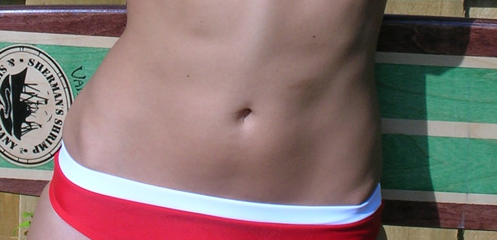 white woman in red and white bikini bottom with slim tummy