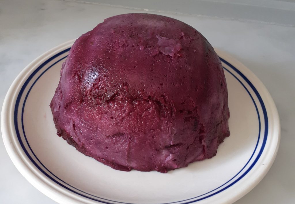 purple pudding on a white china plate