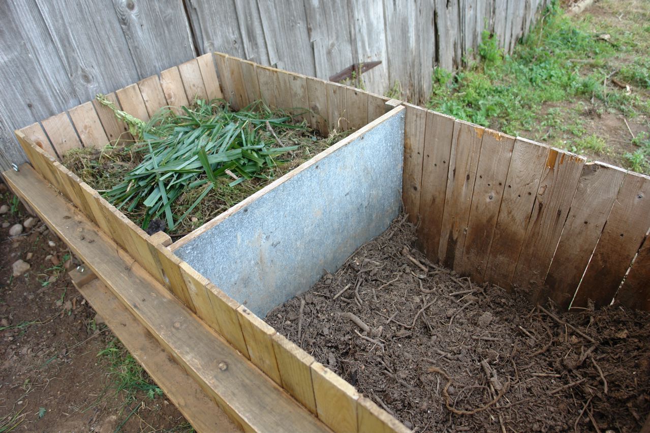 Two container wooden compost bin, half full
