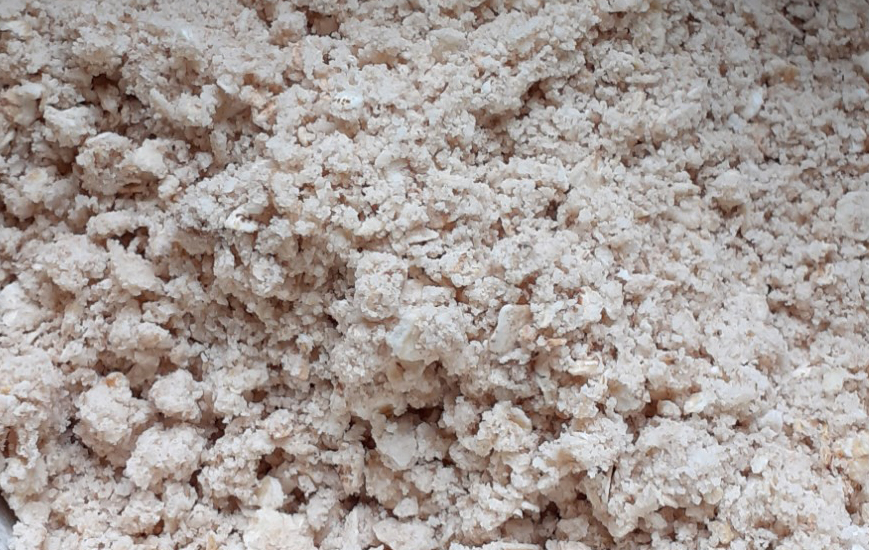 Close-up of pale brown, creamy coloured crumble