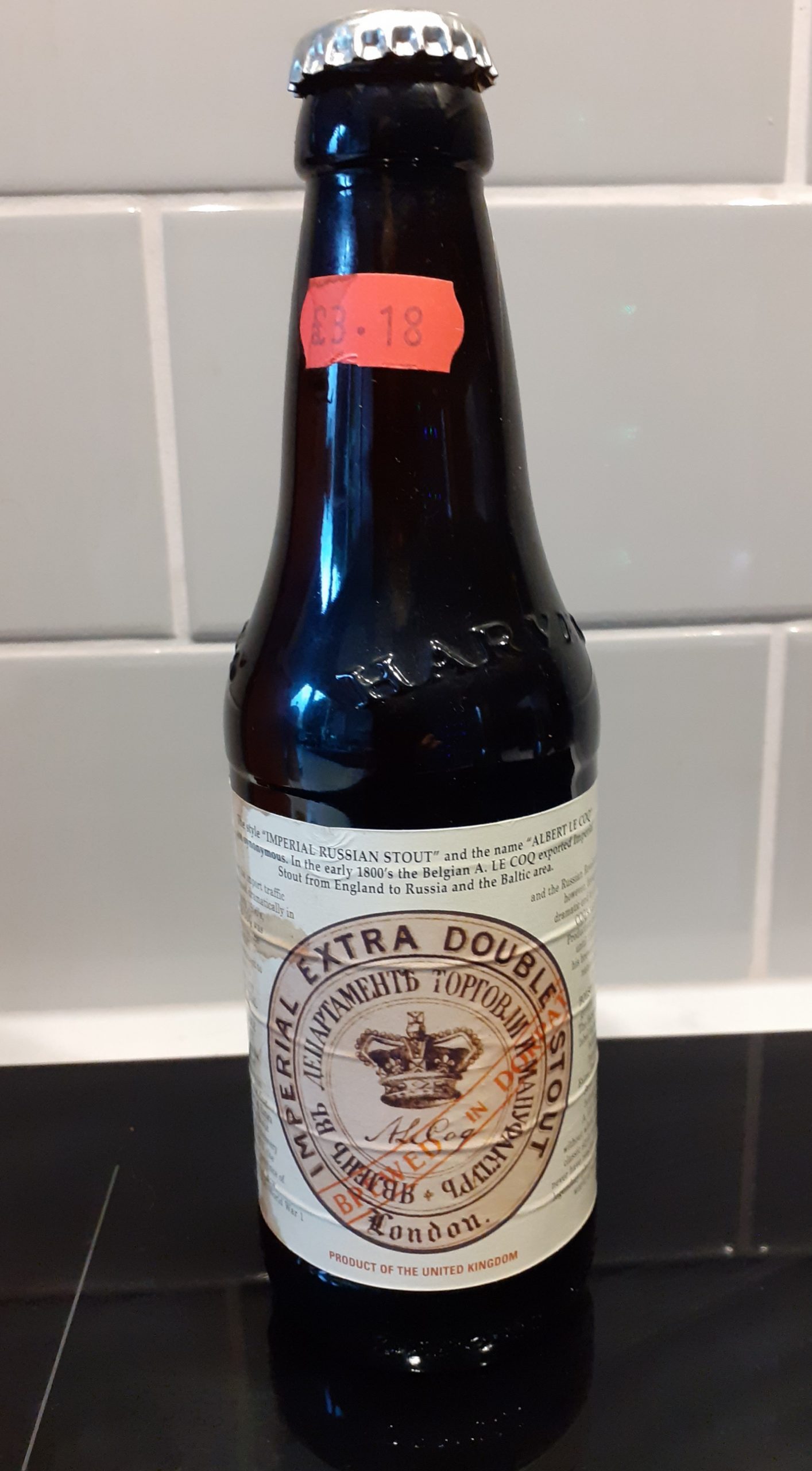 Brown bottle, cream label with brown writing in English and Russian - black base, grey background