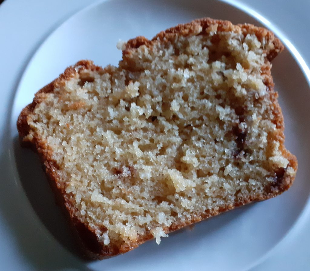 yellow, soft, crumbly slice of loaf cake on white plate